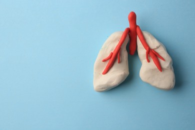 Photo of Human lungs made of plasticine on light blue background, top view. Space for text