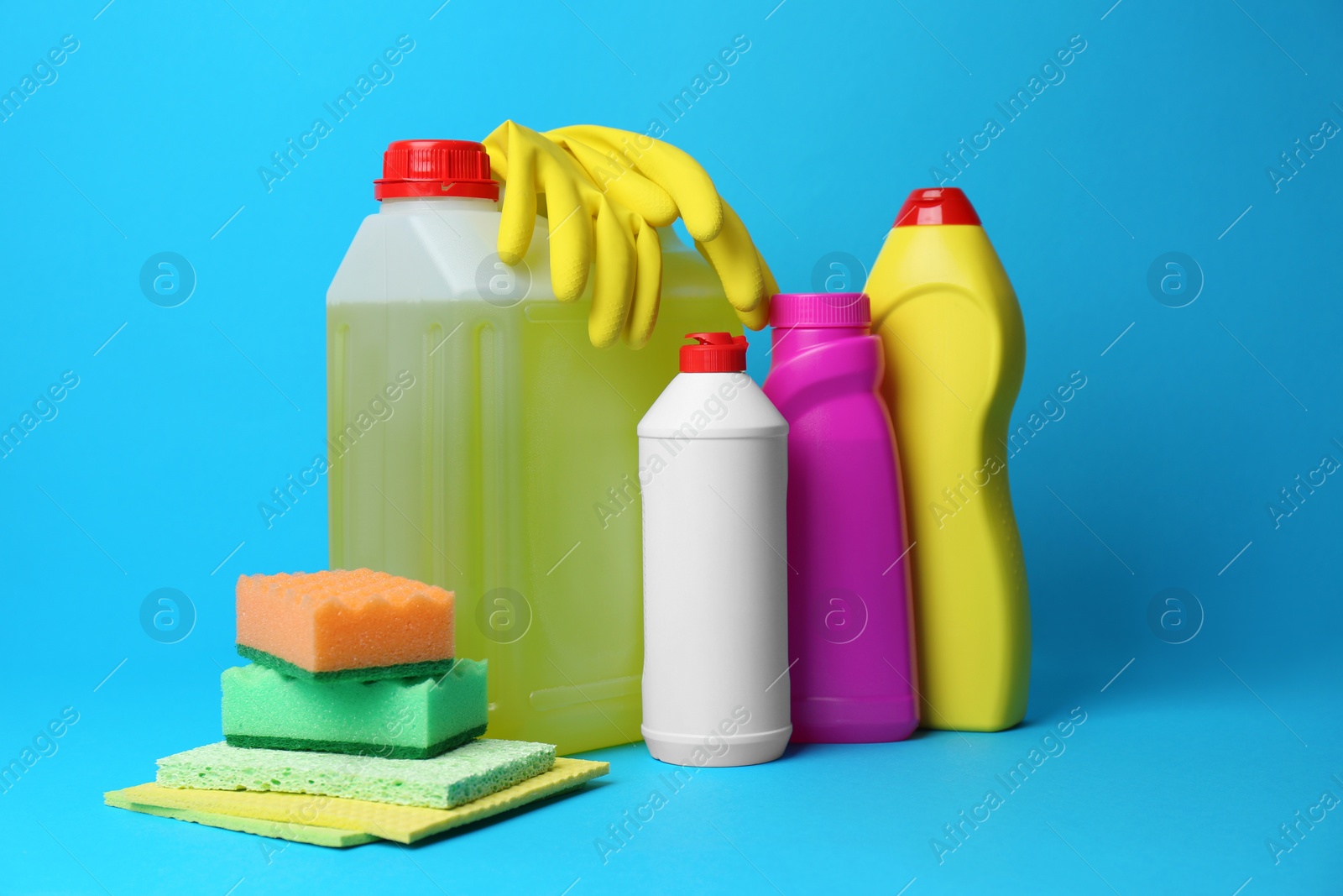 Photo of Cleaning supplies and tools on light blue background