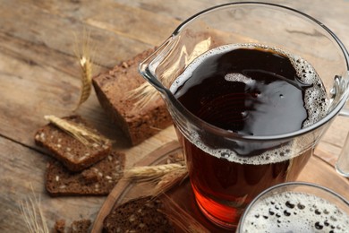 Delicious kvass, bread and spikes on wooden table. Space for text