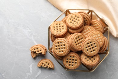 Photo of Tasty sandwich cookies with cream on grey table, flat lay. Space for text