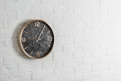 Modern analog clock hanging on white wall, space for text. Time of day