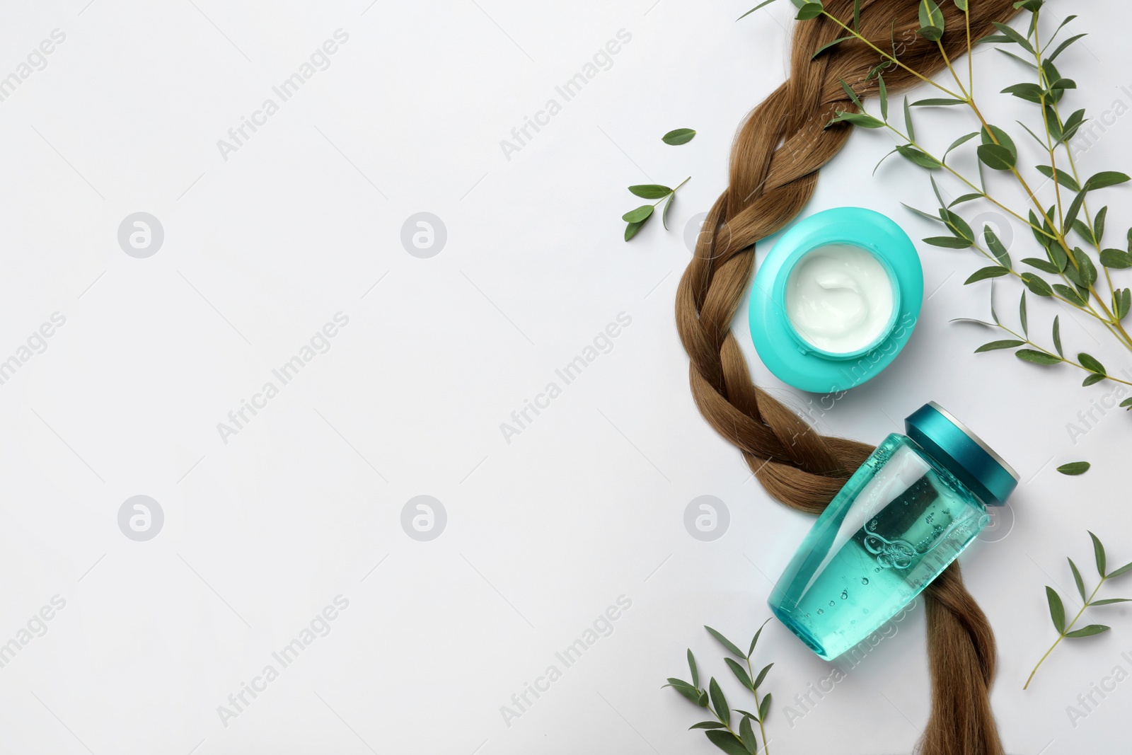 Photo of Natural cosmetic products, green leaves and hair braid on white background, flat lay. Space for text