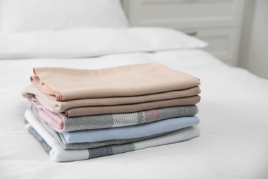 Photo of Stack of folded cashmere clothes on bed