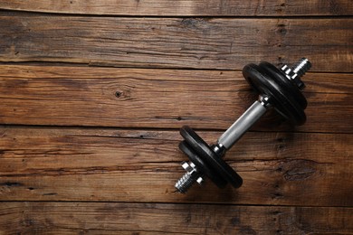 Photo of One barbell on wooden floor, top view. Space for text