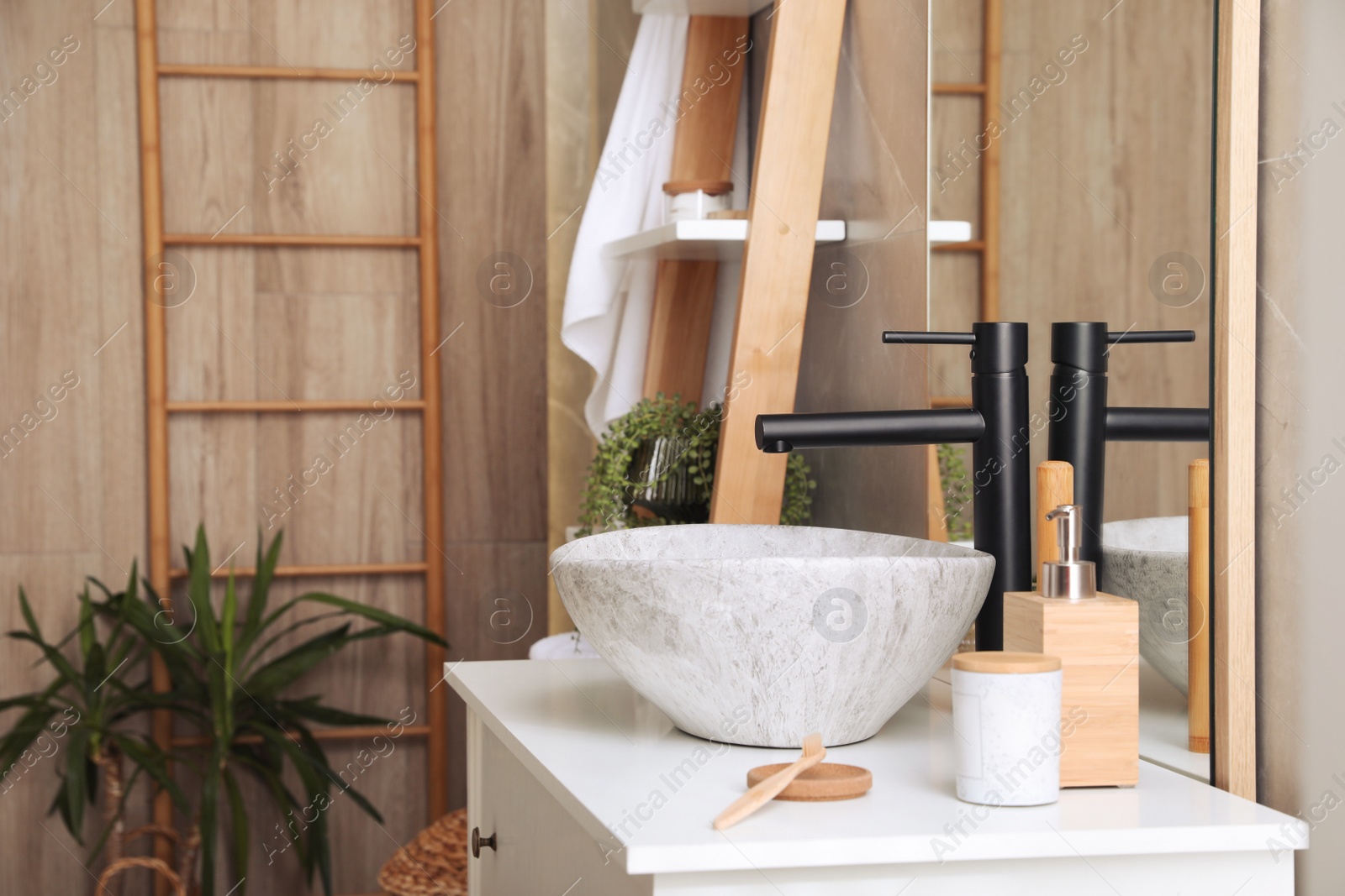 Photo of Chest of drawers with sink, mirror and toiletries in bathroom. Interior design