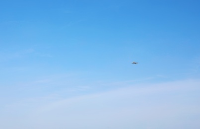 Photo of Distant view of modern airplane in blue sky