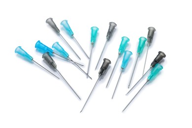 Photo of Many disposable syringe needles on white background