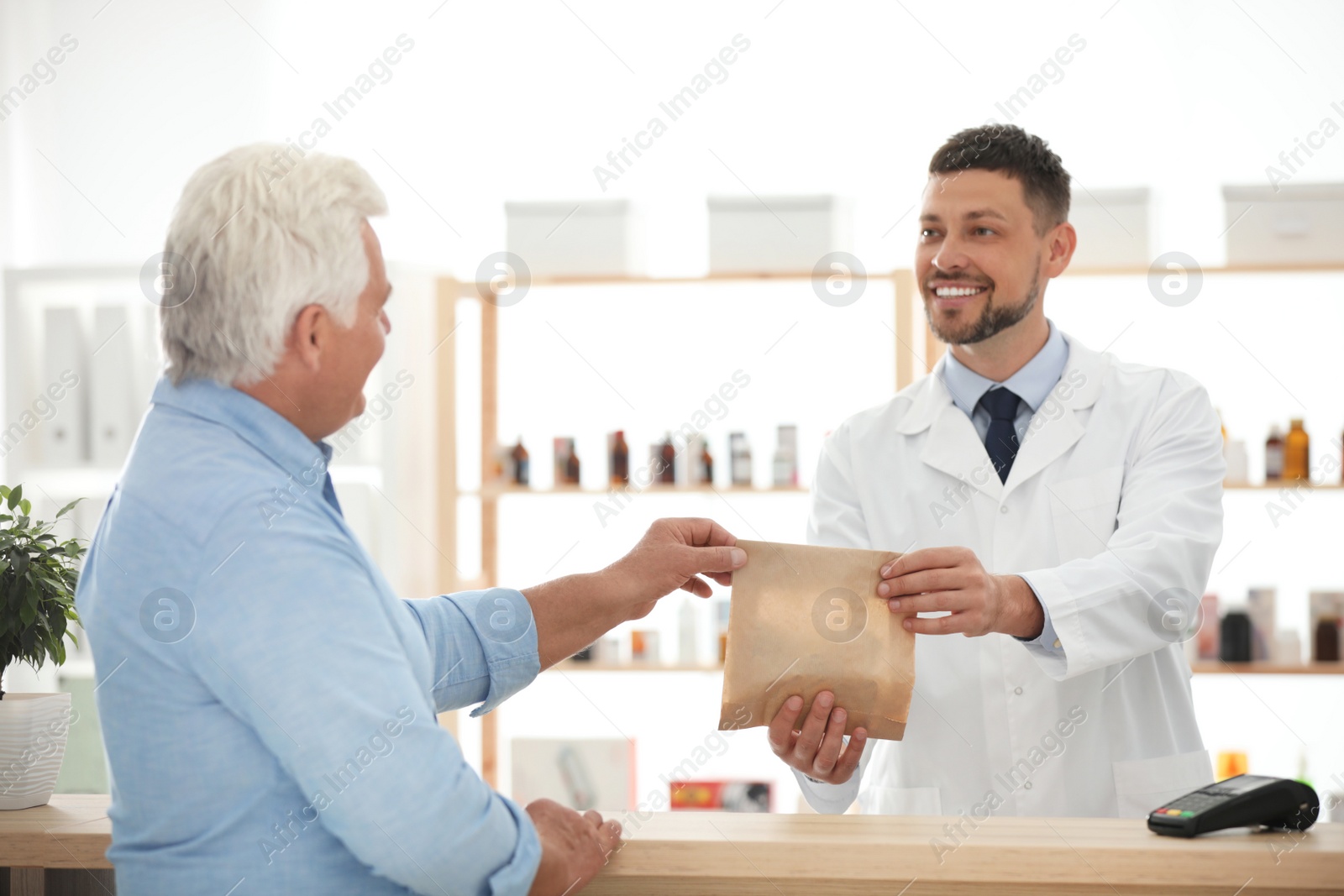 Photo of Pharmacist giving medicine to customer in drugstore