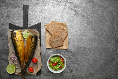 Photo of Flat lay composition with tasty smoked fish on grey table. Space for text