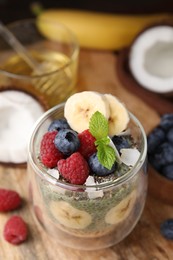 Photo of Tasty oatmeal with chia matcha pudding and fruits on wooden table, closeup. Space for text. Healthy breakfast
