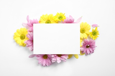 Photo of Composition with beautiful chamomile flowers and blank card on white background, top view. Space for text