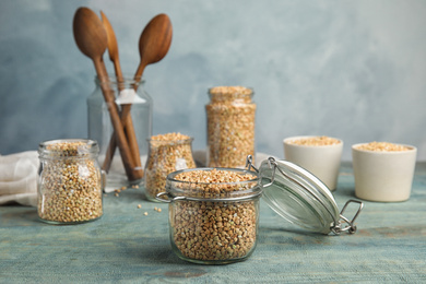 Uncooked green buckwheat grains on light blue wooden table