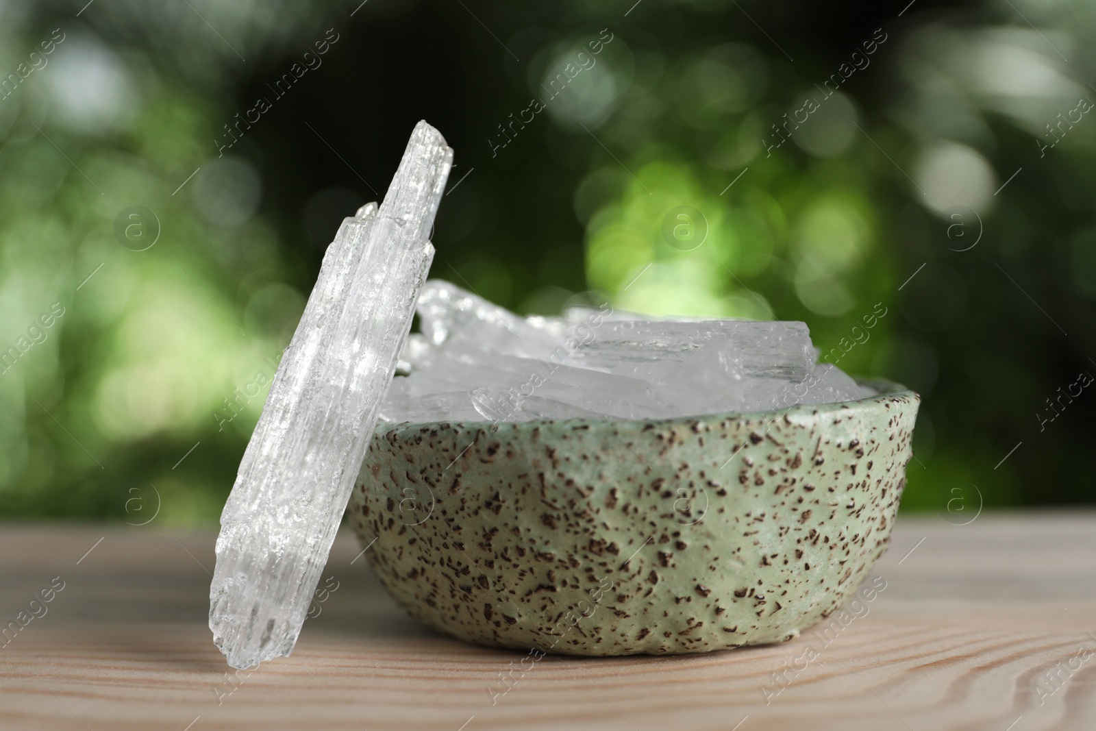 Photo of Menthol crystals on wooden table against blurred background
