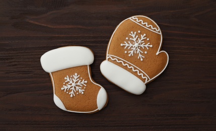 Photo of Mitten and stocking shaped Christmas cookies on wooden table, flat lay
