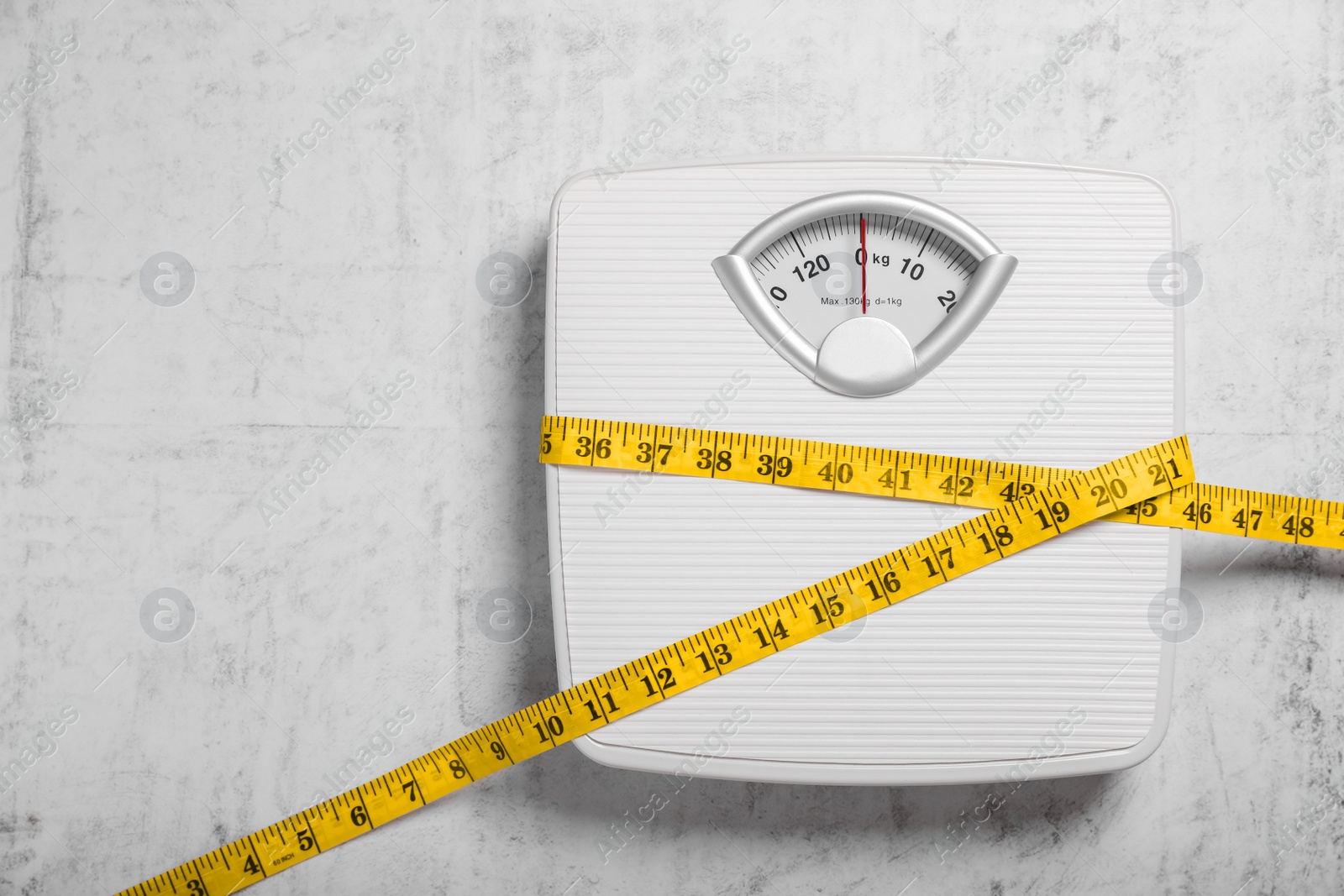 Photo of Weight loss concept. Scales and measuring tape on grey textured background, top view. Space for text