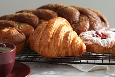 Photo of Different tasty freshly baked pastries on white wooden table, closeup