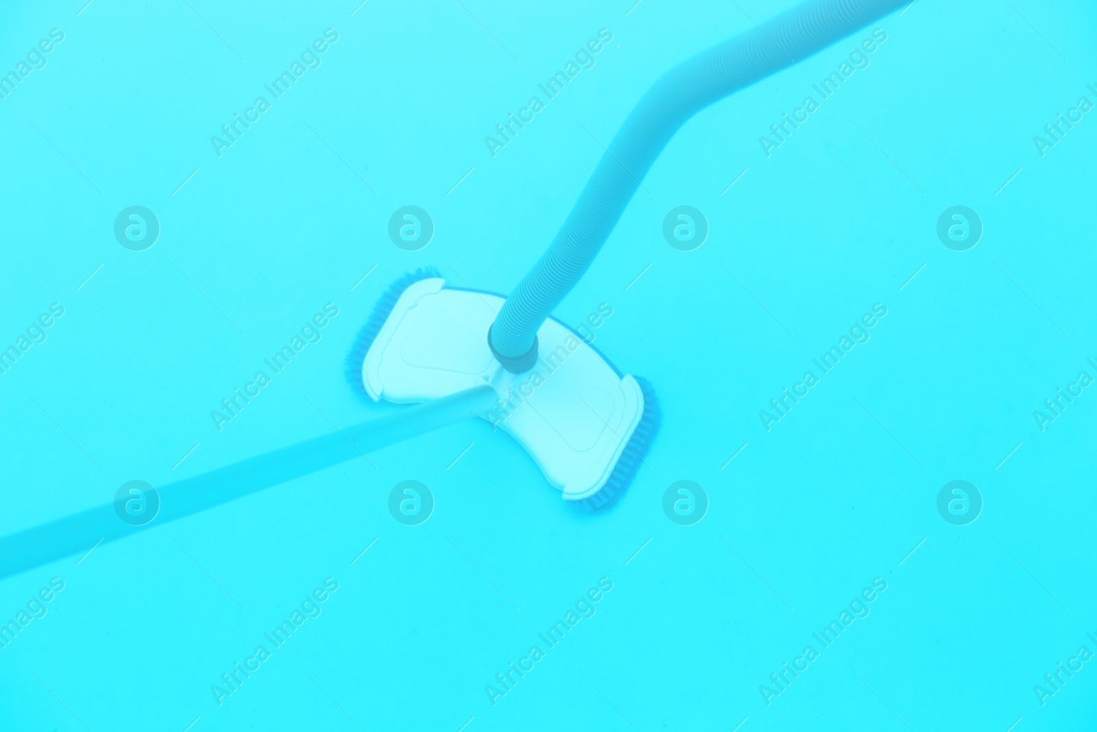 Photo of Cleaning outdoor pool with underwater vacuum, closeup