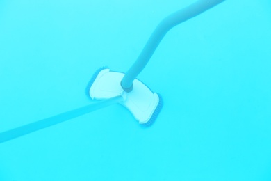 Photo of Cleaning outdoor pool with underwater vacuum, closeup