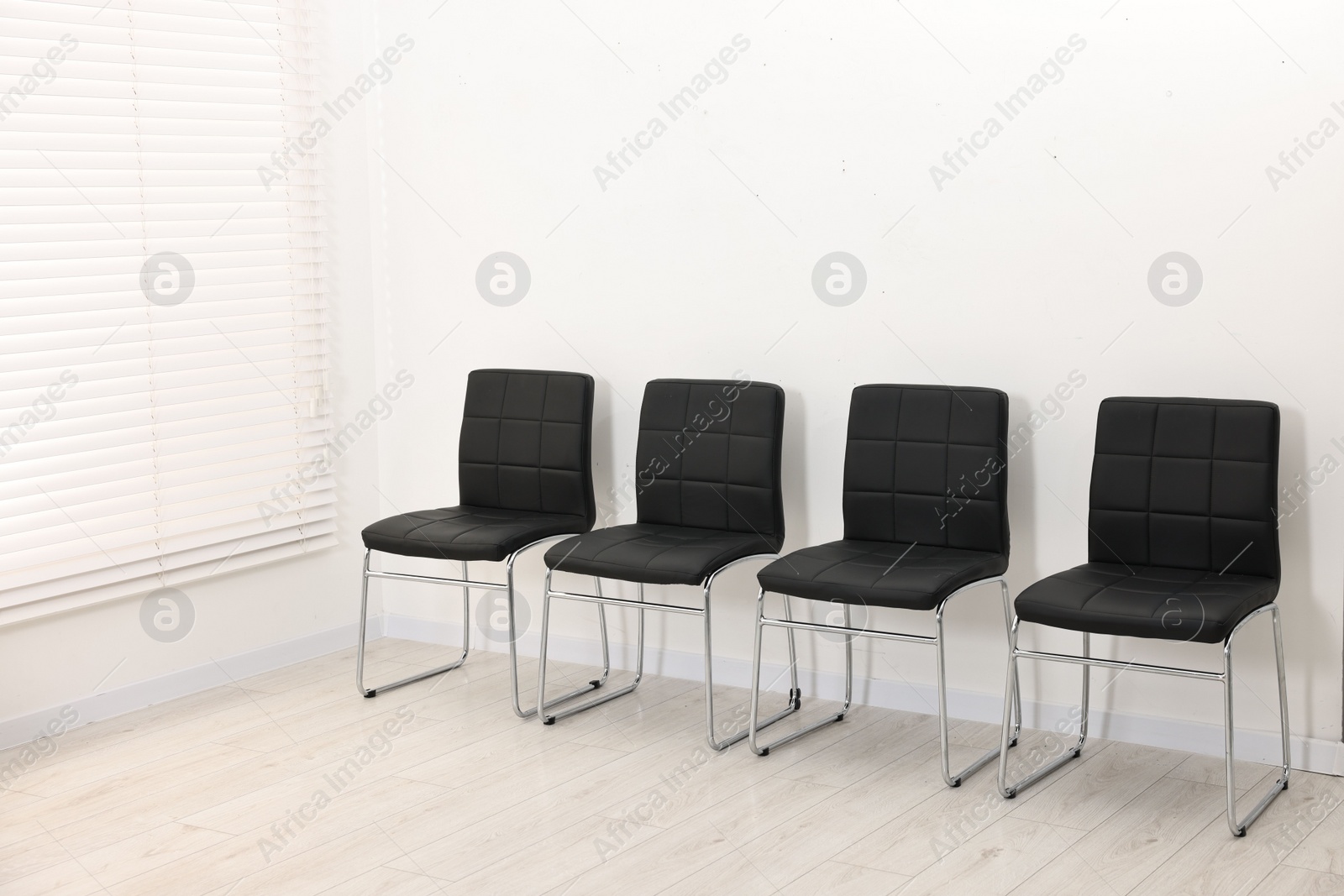 Photo of Many chairs near white wall in waiting area indoors