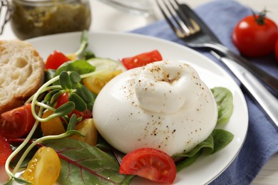 Photo of Delicious burrata salad with tomatoes served on table, closeup