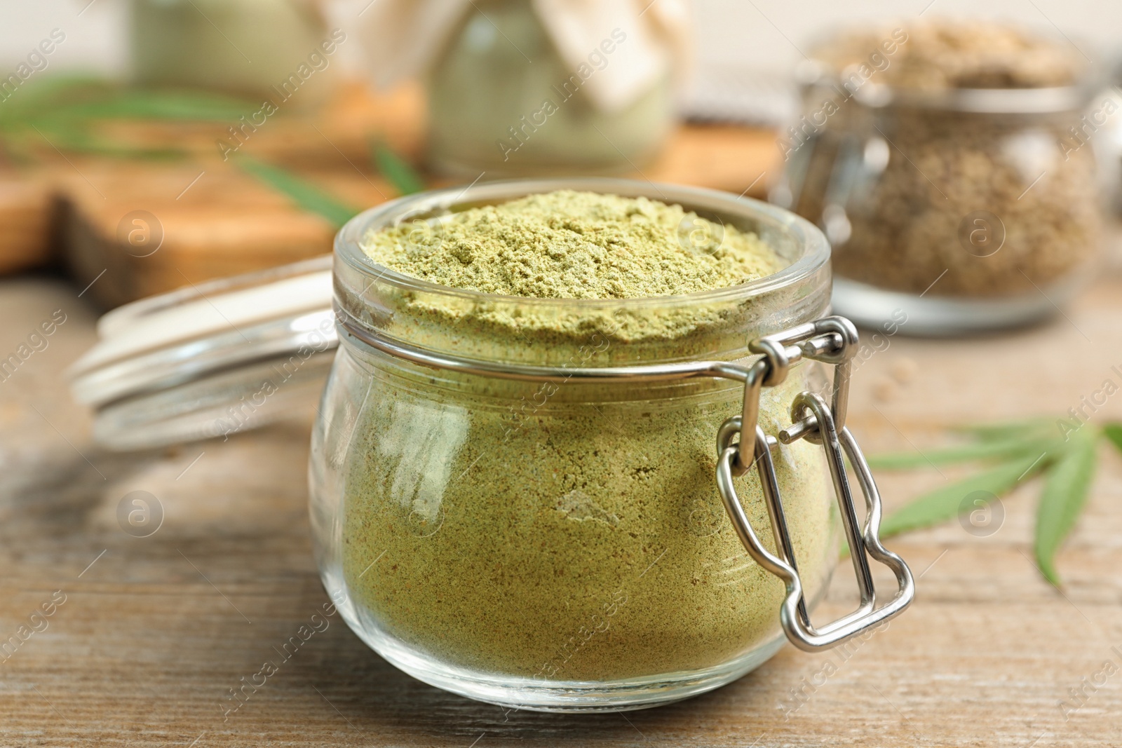 Photo of Jar of hemp protein powder on wooden table, closeup