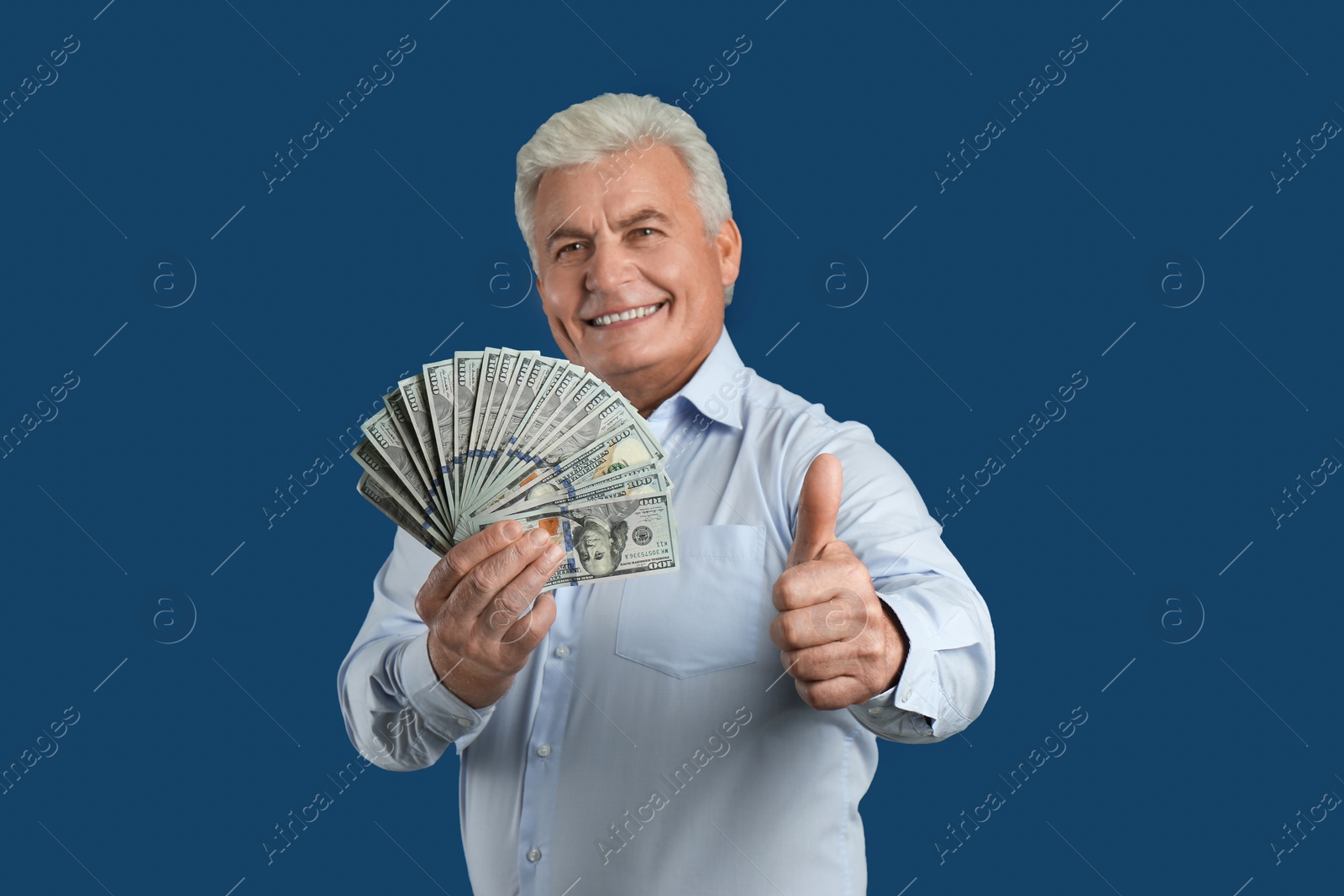 Photo of Happy senior man with cash money on blue background