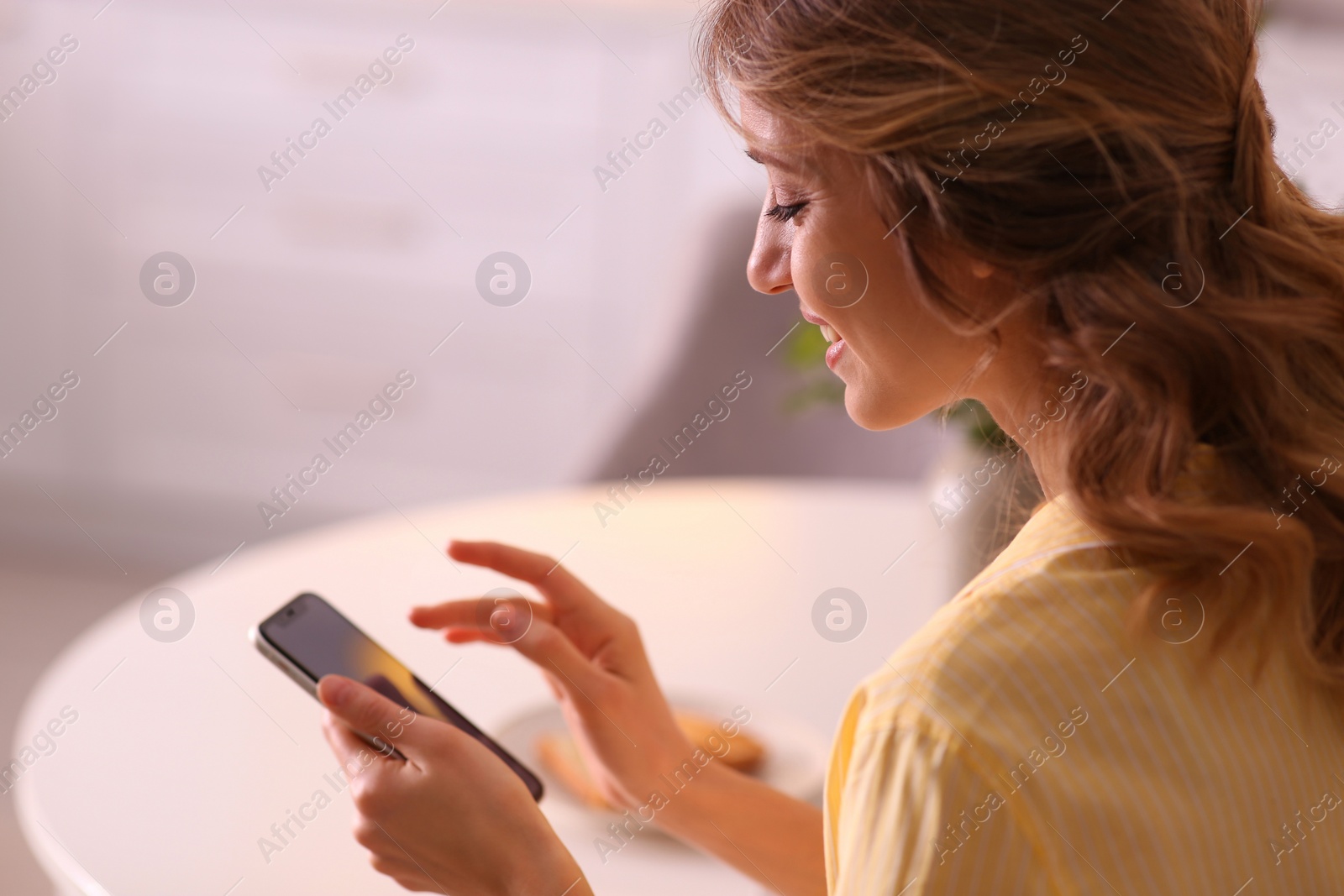 Photo of Beautiful young woman with smartphone relaxing at home. Weekend morning