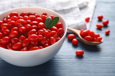 Photo of Fresh ripe goji berries in bowl on blue wooden table, closeup