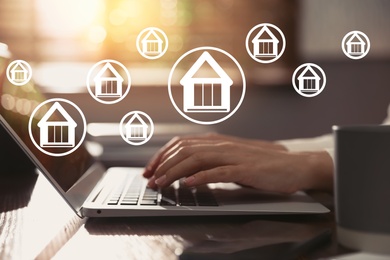 Property search concept. Woman using laptop at table, closeup