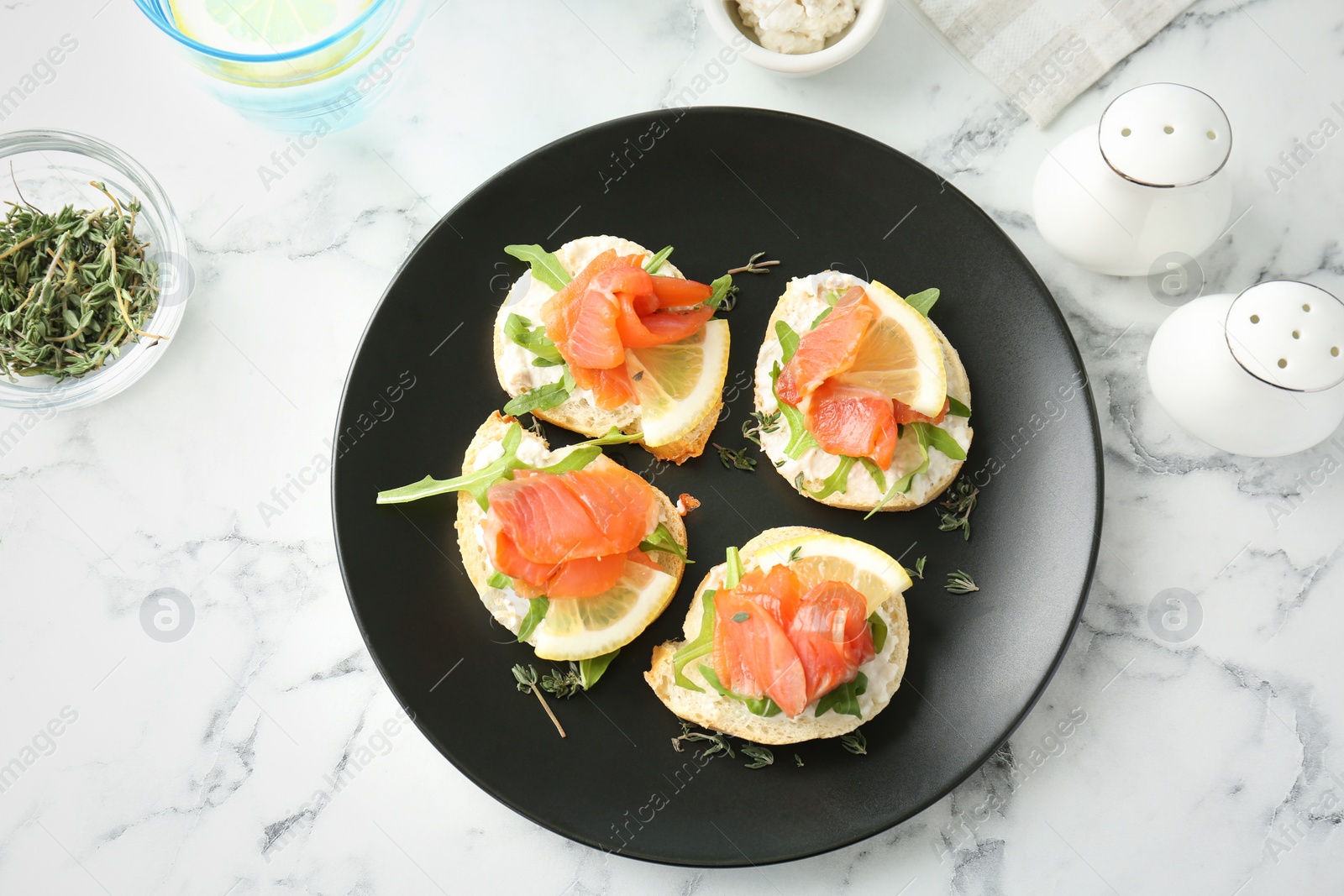 Photo of Plate of tasty sandwiches with fresh sliced salmon fillet on table, top view