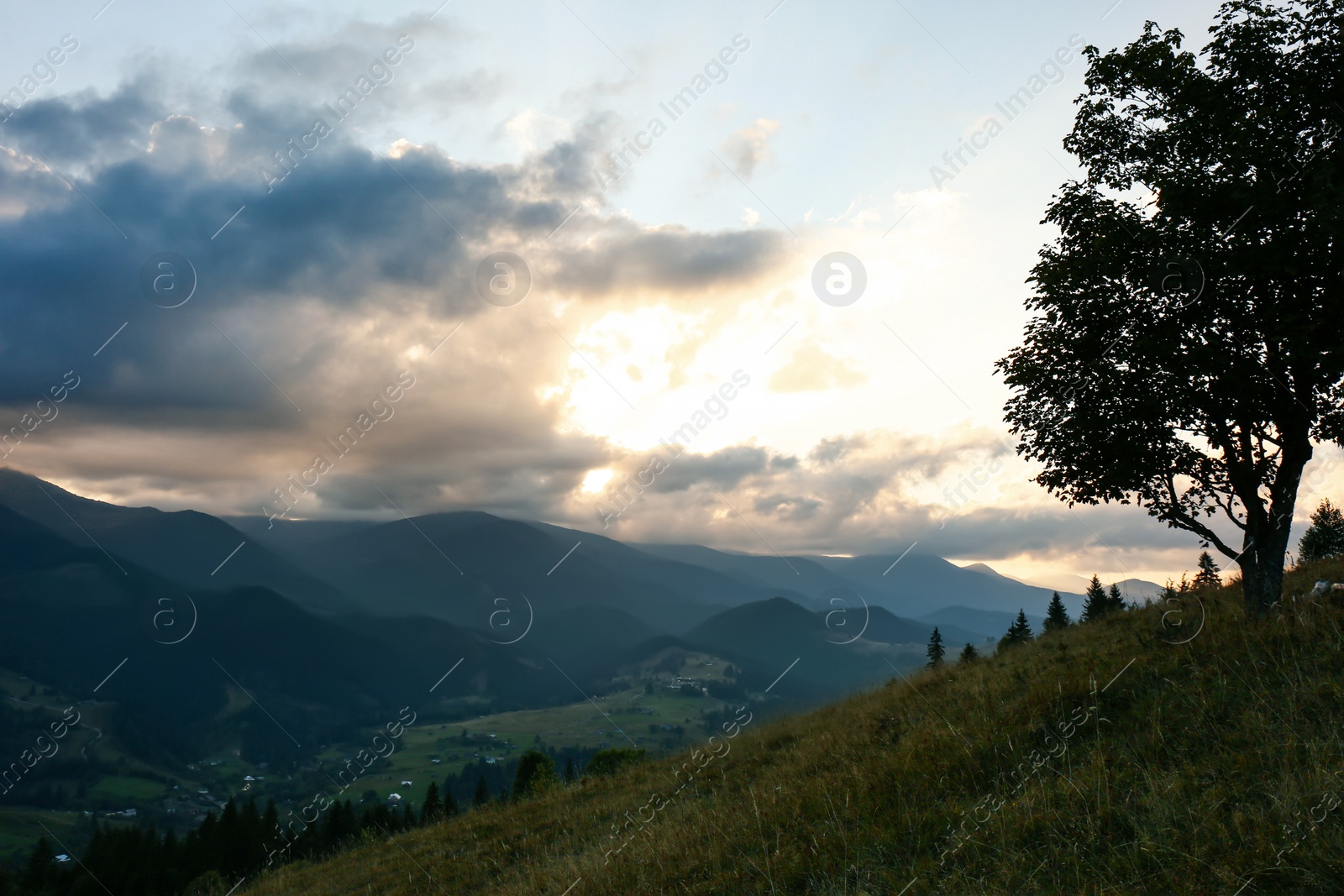 Photo of Beautiful mountains under cloudy sky at sunset. Picturesque landscape