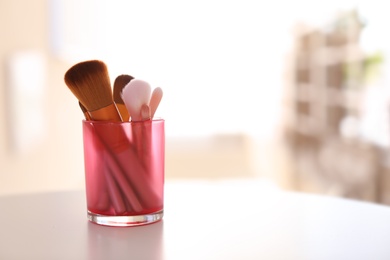 Photo of Holder with makeup brushes on table