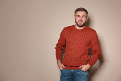 Image of Handsome man wearing warm sweater on beige background. Space for text