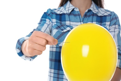 Woman piercing yellow balloon on white background, closeup