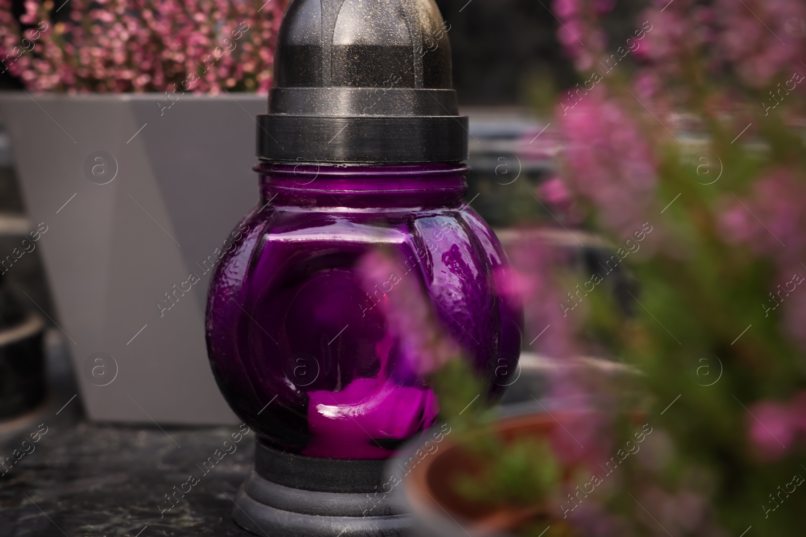 Photo of Grave lantern on granite surface at cemetery, closeup