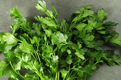 Bunch of fresh green parsley leaves on grey table, top view