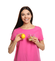 Beautiful young woman with tasty lemon water and fresh fruit on white background