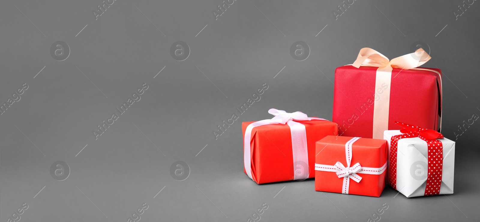 Image of Beautiful gift boxes with ribbons and space for text on grey background. Banner design