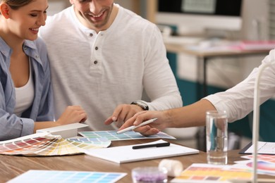 Photo of Interior designer consulting young couple in office, closeup
