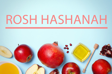 Honey, apples and pomegranates on light blue background, flat lay. Rosh Hashanah holiday