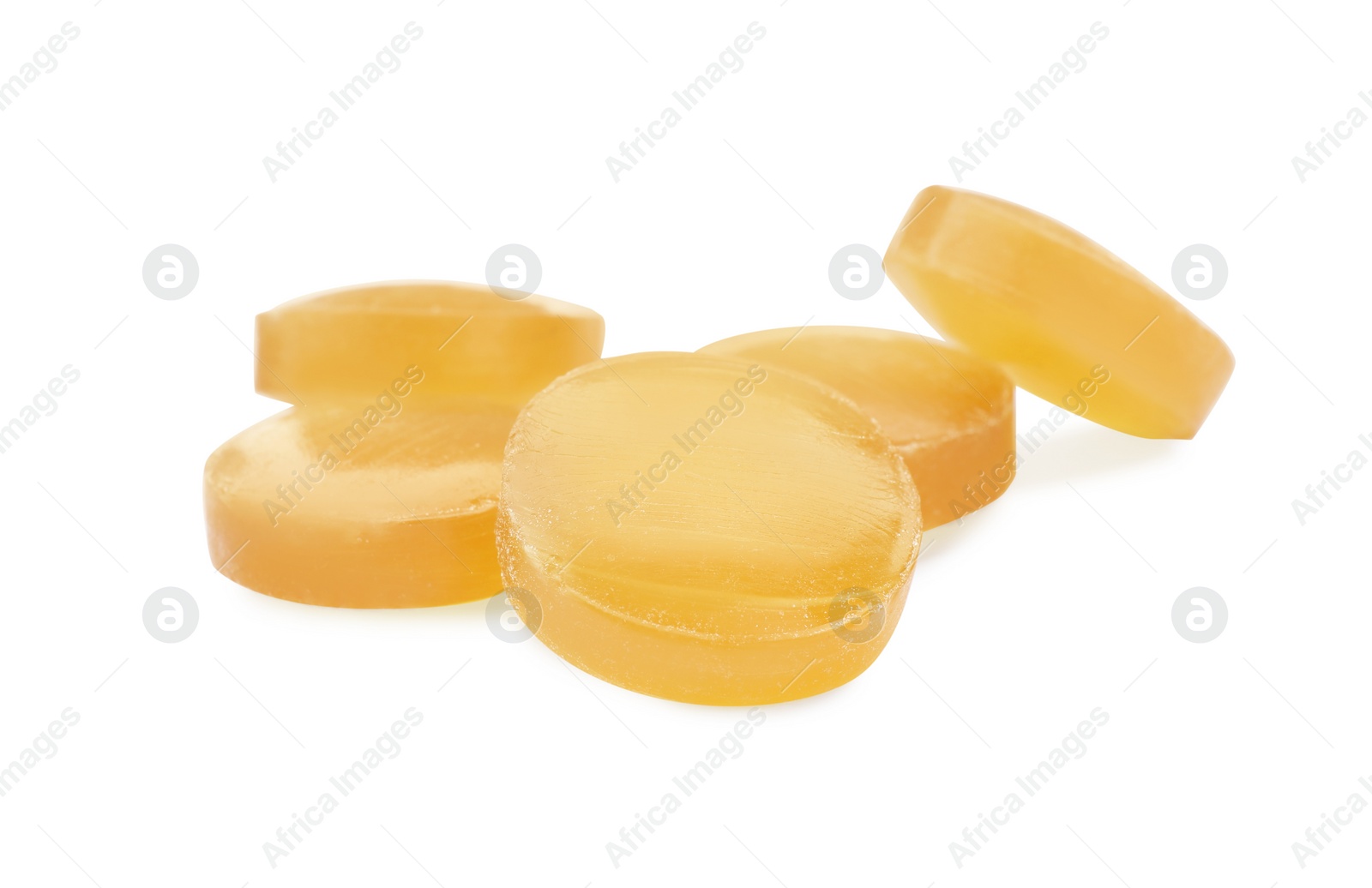 Photo of Many yellow cough drops on white background