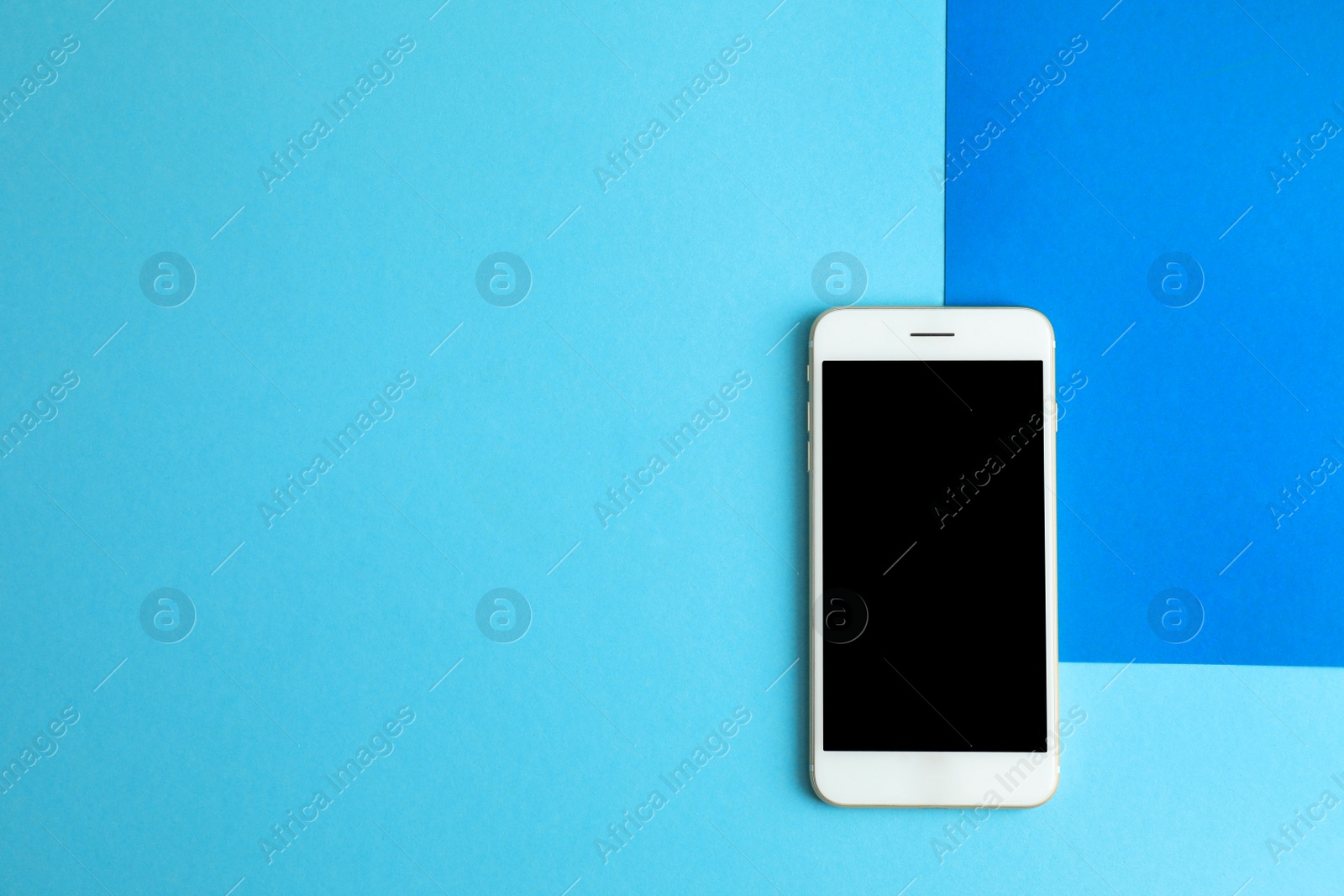 Photo of Modern phone on blue background, top view. Space for text