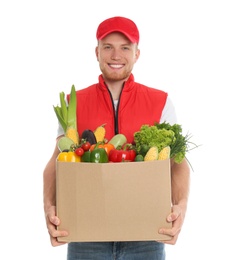 Photo of Delivery man with box of fresh vegetables on white background