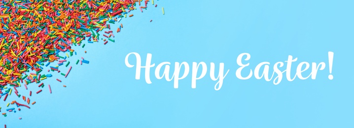 Image of Text Happy Easter and colorful sprinkles on light blue background, flat lay. Confectionery decor