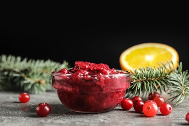 Photo of Glass bowl with tasty cranberry sauce on table