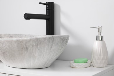 Photo of Different bath accessories and personal care products near sink on bathroom vanity