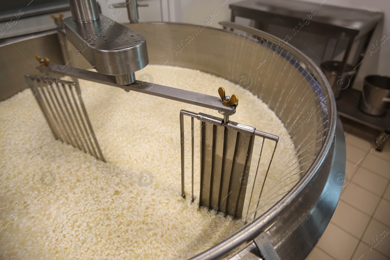 Photo of Adding water to curd and whey in tank at cheese factory