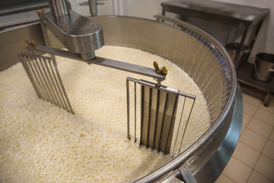 Photo of Adding water to curd and whey in tank at cheese factory