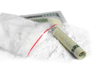 Photo of Cocaine in plastic bag and rolled money bill on white background