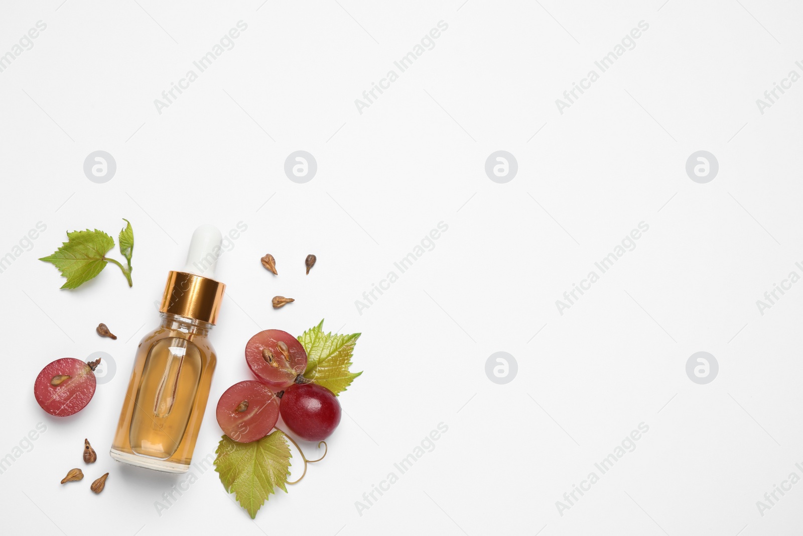 Photo of Composition with bottle of natural grape seed oil on white background, top view. Organic cosmetic